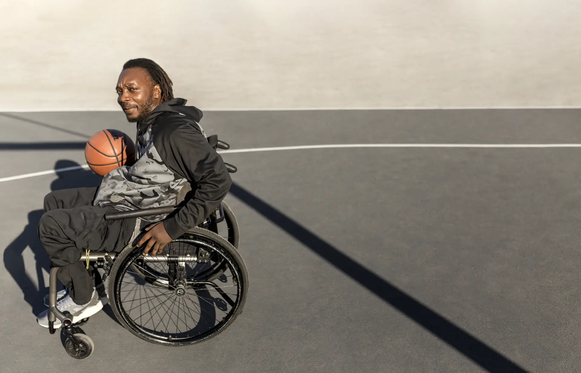 Person in wheelchair playing basketball - living independently with support